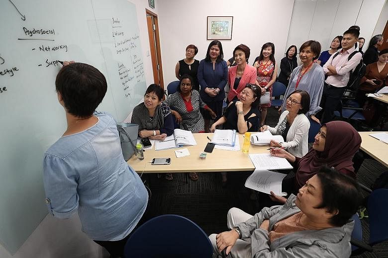 Senior Parliamentary Secretary for Manpower and Education Low Yen Ling (in pink blazer) observing a LifeWork course for mature workers with Centre for Seniors executive director Lim Sia Hoe (in pale grey, standing).