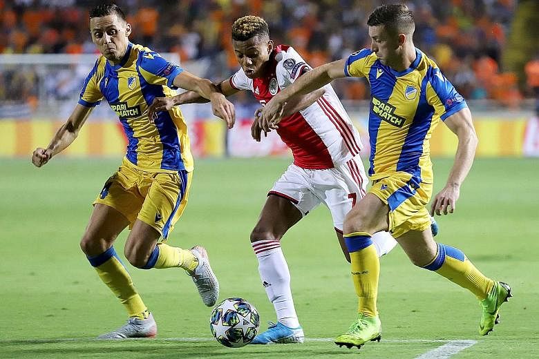 Ajax forward David Neres (centre) is challenged by Apoel Nicosia players during the Uefa Champions League play-off match at the GSP stadium in Nicosia on Tuesday. PHOTO: AGENCE FRANCE-PRESSE