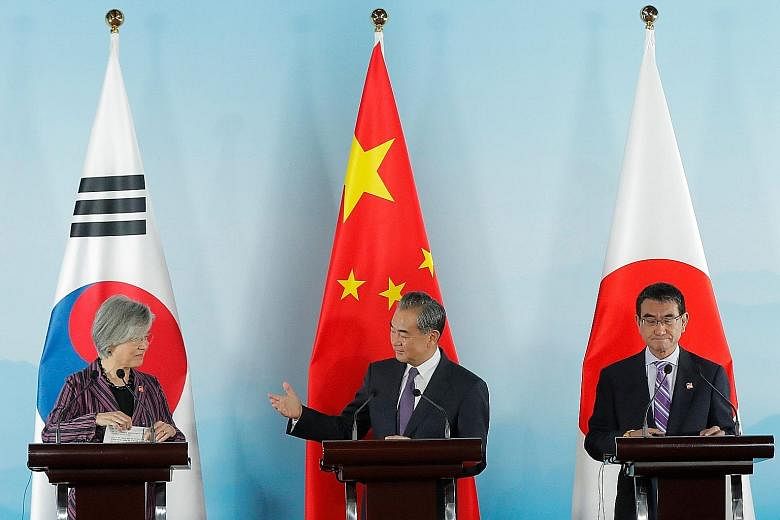 Chinese Foreign Minister Wang Yi (centre) with South Korean Foreign Minister Kang Kyung-wha (left) and Japanese Foreign Minister Taro Kono at a press conference after their meeting in Beijing yesterday. China, Japan and South Korea agreed to continue