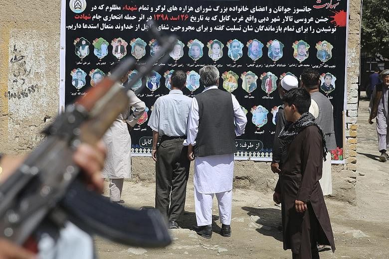A banner with pictures of victims of last Saturday's wedding party bombing in Kabul, which was claimed by ISIS. Afghan officials say ISIS has been reduced to staging suicide attacks against "soft" targets, but border province leaders say ISIS forces 