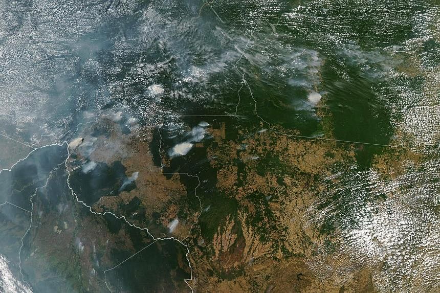 A photo from Nasa's Aqua satellite showing fires burning across Brazil. The blazes are so large and widespread that smoke has wafted thousands of miles away to the Atlantic coast and Sao Paulo, the country's most populous city, says the World Meteoro