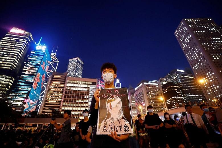 A student holding a poster depicting a female protester whose eye was injured, at a rally calling for political reforms outside City Hall in Hong Kong yesterday. Some felt it was unjust that only two people in the Yuen Long attack have been charged s