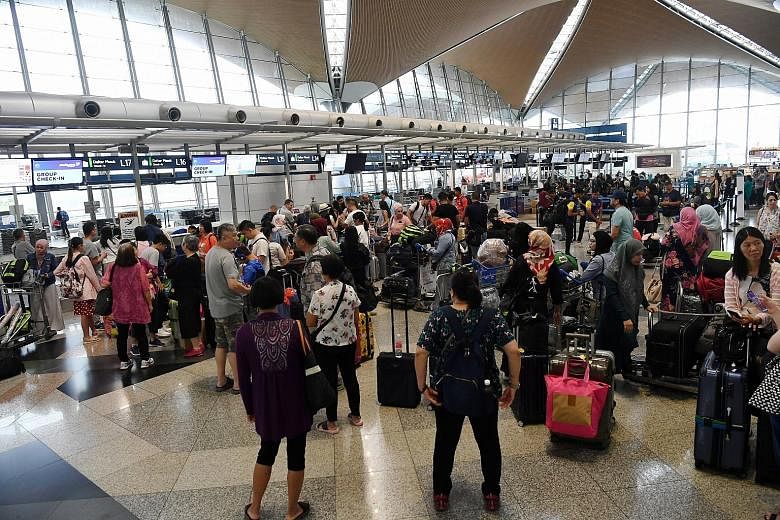The scene at Kuala Lumpur International Airport yesterday after disruptions affected airport systems such as check-in and baggage handling. PHOTO: BERNAMA