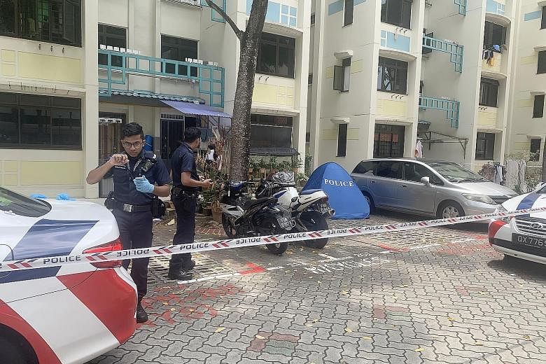 The police at the foot of Block 26 Toa Payoh East where an 84-year-old man's body was found. He is believed to have fallen from the 10th storey, where he lived in a unit with his wife. She reportedly died in hospital after suffering a heart attack on