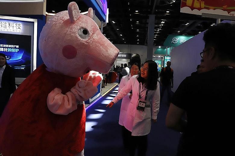 A Peppa Pig mascot at a conference in Beijing. Hasbro's acquisition of Entertainment One adds the character and a suite of other children's media properties to its portfolio of bankable brands. PHOTO: ASSOCIATED PRESS