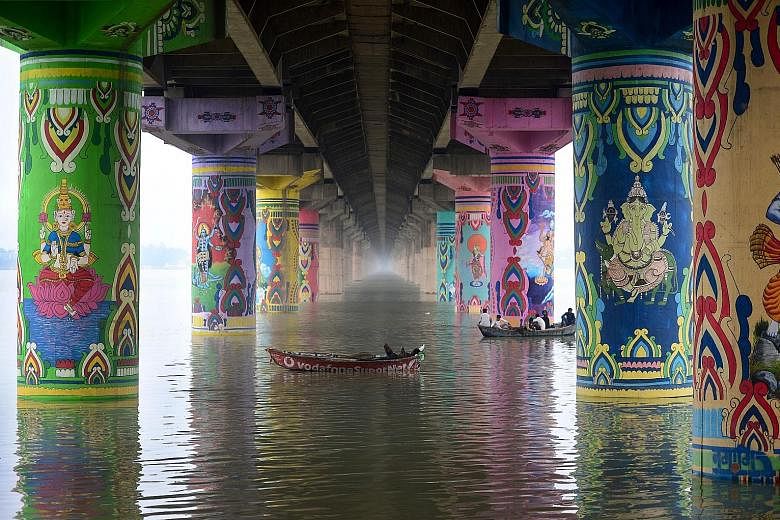 Boats sailing on the Ganges river under the Shastri bridge in the city of Prayagraj, in India's northern state of Uttar Pradesh, on Thursday. The bridge's pillars were given a new look as part of the "Paint My City" project last December for the Kumb