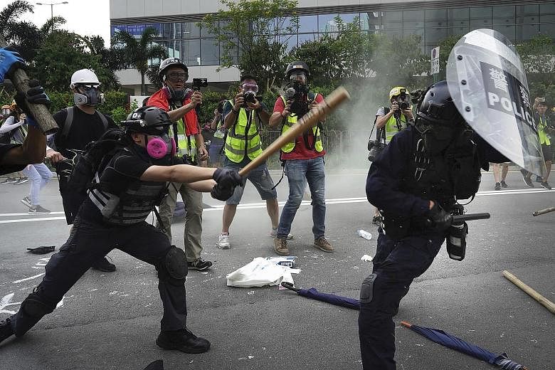 Violence erupted during anti-government protests in Hong Kong yesterday as protesters and riot police exchanged Molotov cocktails and tear gas, after a week of relative calm. Amid concerns that the authorities could potentially use technology to iden