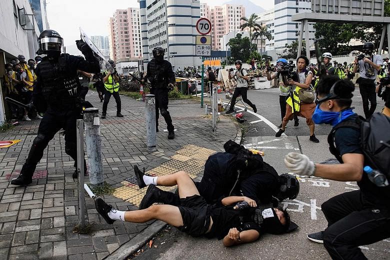 Hong Kong riot police yesterday clashing with protesters, who retaliated with a barrage of stones, bottles and bamboo poles, as a stand-off descended into violence.