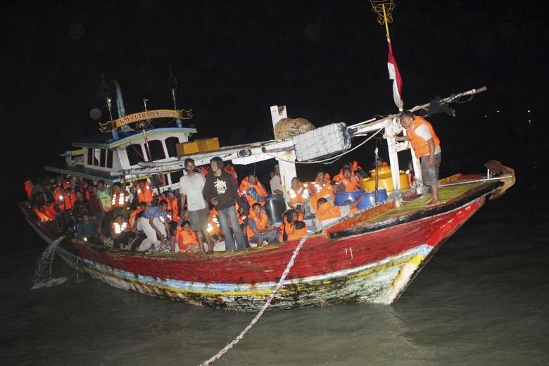 Rescued passengers of the KM Santika Nusantara (above), the ferry that caught fire last Thursday off the coast of Java, waiting at Tanjung Perak seaport in Surabaya and getting their particulars recorded after being evacuated last Friday, the same da