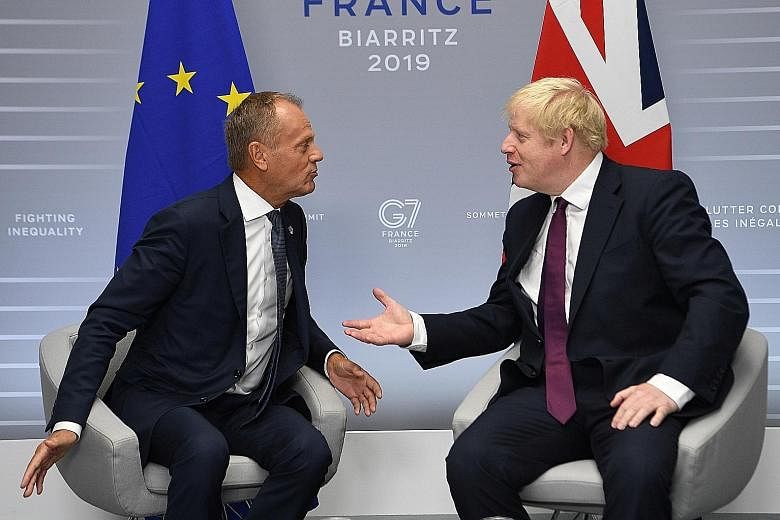 European Council President Donald Tusk (left) and British Prime Minister Boris Johnson at a bilateral meeting during the Group of Seven summit in Biarritz yesterday. Uncertainty over Brexit has roiled markets.