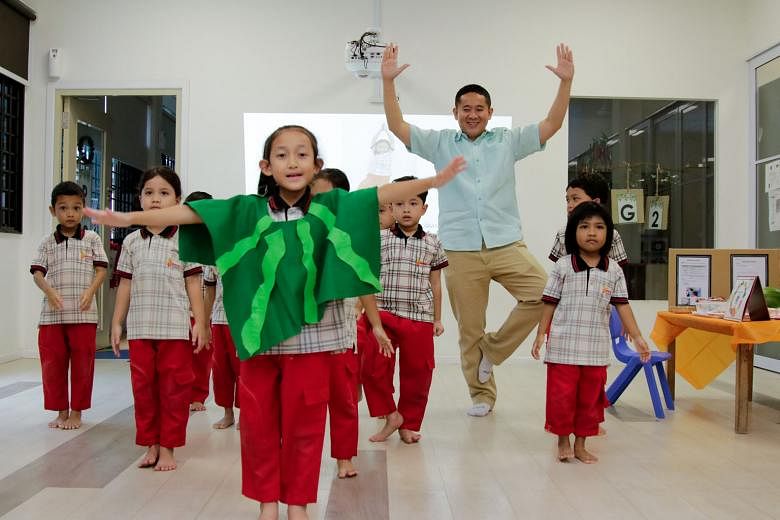 Senior Parliamentary Secretary for Health and Home Affairs, Mr Amrin Amin, with pre-school children in a yoga session at the Singapore Muslim Women's Association (PPIS) Child Development Centre in Bukit Batok yesterday. Apart from teaching the childr