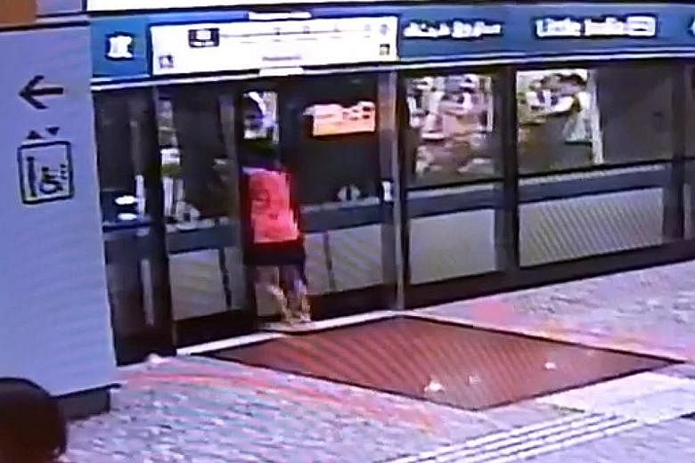 In a screen grab of a video shared on social media, a woman is seen prising open the platform doors before attempting to force open the train doors. The clip also shows commuters trying to help her.