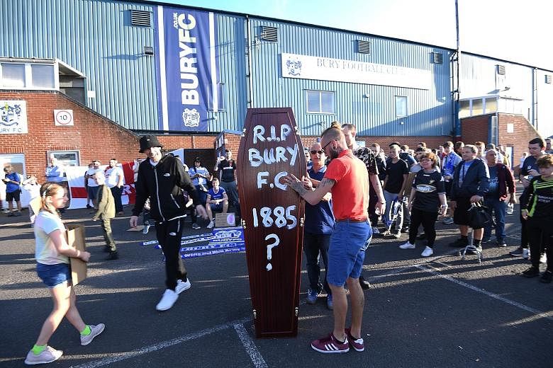 Bury Football Club supporters carrying a mock coffin outside their Gigg Lane stadium. The League One club, two-time winner of the FA Cup, has been expelled from the English Football League over financial insolvency. PHOTO: EPA-EFE