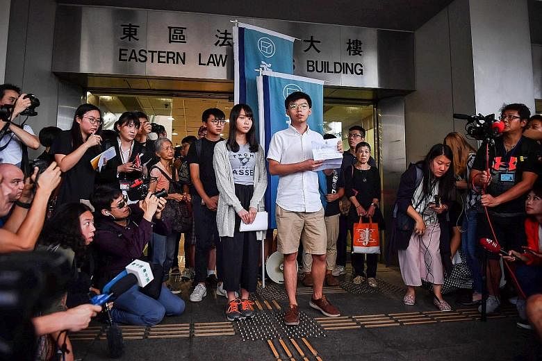 Demosisto party's leader Joshua Wong and member Agnes Chow speaking to the press yesterday at the Wan Chai police headquarters after being released on bail. They are accused of taking part in a June 21 unauthorised demonstration outside Wan Chai poli