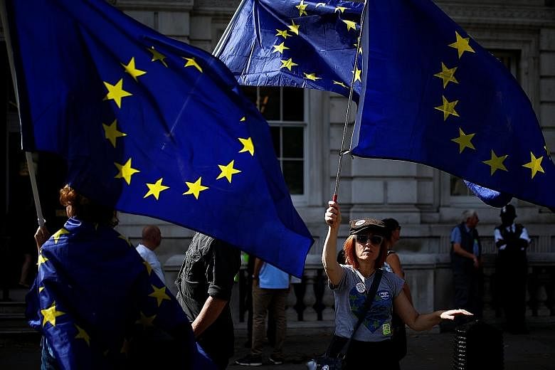 Anti-Brexit protesters waving European Union flags outside the Cabinet Office in London yesterday. Britain's negotiators are to meet their EU counterparts throughout next month in a bid to reach a new divorce deal.