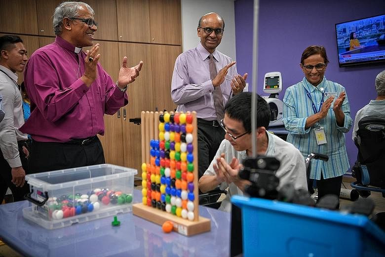 Senior Minister Tharman Shanmugaratnam is flanked by Right Reverend Rennis Ponniah, president of the Singapore Anglican Community Services and St Andrew's Mission Hospital, and Ms Namrata Sadarangani, assistant director of community therapy services 