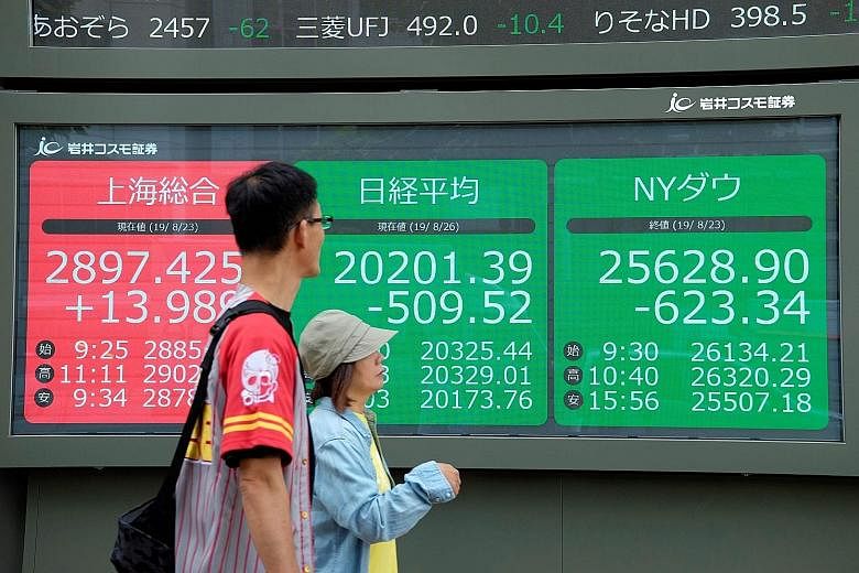 Stock quotation boards in Tokyo last Monday showing prices on the stock exchanges of (from left) Shanghai, Tokyo and New York. The writer cites history to show that the longer you hold your equities portfolio, the higher the probability that it would