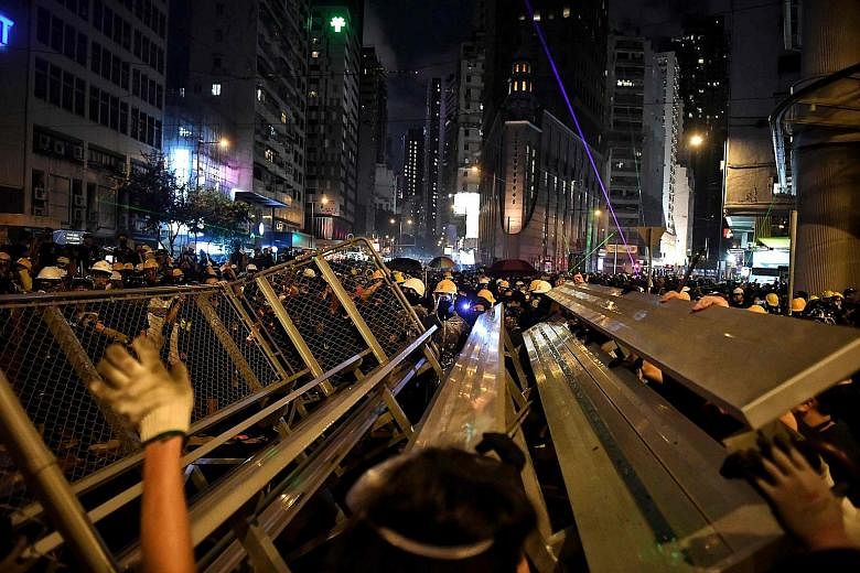 Above: Protesters building a barricade in Hennessy Road in Hong Kong yesterday, in the latest opposition to a planned extradition law that has since morphed into a wider call for democratic rights in the semi-autonomous city. They have taken to the s