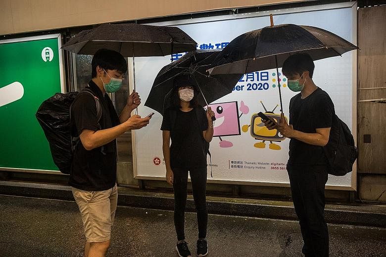 Some friends checking the Telegram message boards to see where other protesters are. Hong Kong protesters use encrypted apps to mobilise swiftly through multiple group chats.