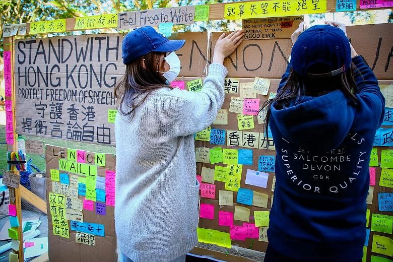 Supporters of the Hong Kong pro-democracy protests posting notes on a board at the University of Queensland in Brisbane, Australia, last month. A clash at the university between pro-democracy and pro-Beijing protesters during a demonstration over the