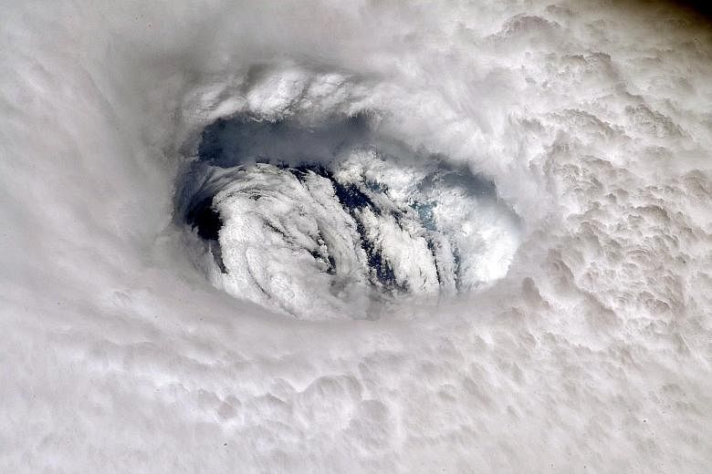 An image of Hurricane Dorian's eye taken by a Nasa astronaut from the International Space Station on Monday. Waves splashing against the shoreline in Titusville in the US state of Florida on Monday. Hurricane Dorian was expected to approach the Flori