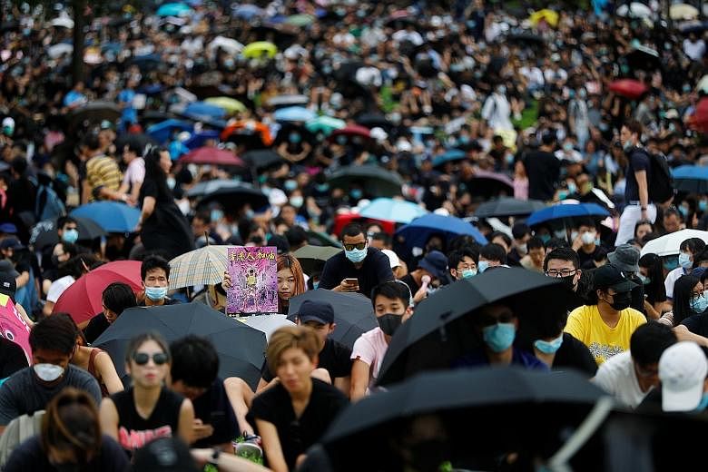 Secondary school students in Hong Kong joining hands to form a human chain as they boycotted classes for a second day and joined pro-democracy rallies. PHOTO: REUTERS People participating in a protest rally at Tamar Park in front of government buildi