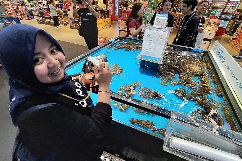 Ms Utari Octavianty at Freshippo, Alibaba's robot-driven supermarket, in Hangzhou, on Aug 28, under the Tech for Inclusion workshop. She is interested in the seafood supply chain as she is the co-founder of Aruna, an Indonesian fisheries e-commerce start-
