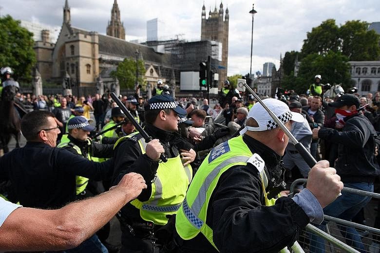 Demonstrators remonstrating with police officers during an anti-government protest calling for Prime Minister Boris Johnson's resignation, near Downing Street in Central London yesterday. On Friday, the House of Lords gave its approval to a Bill to b