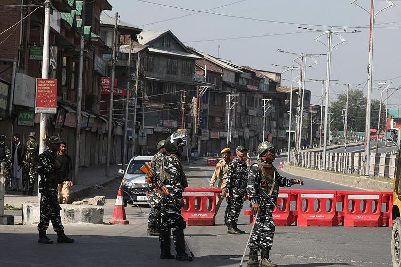 Indian police and soldiers standing guard near a barricade in Srinagar, India, yesterday. The authorities imposed restrictions in parts of Srinagar to prevent Shi'ite Muslims from taking part in a mourning procession during the Islamic holy month of 