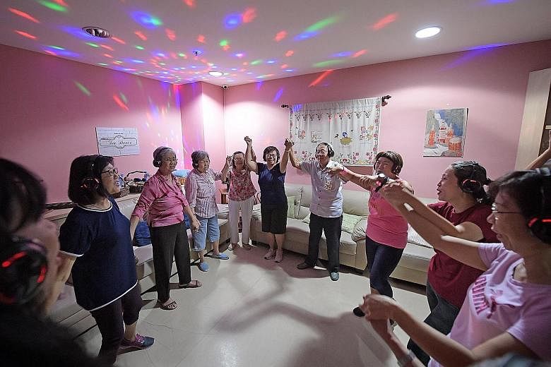 A silent disco session being led by facilitator Karrayl Sim (third from right) at Alzheimer's Disease Association's New Horizon Centre in Jurong Point last Wednesday. Among the participants were Madam Lily Goh (third from left), as well as husband-an