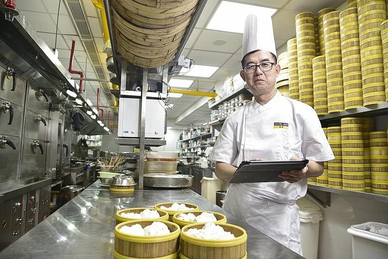 Besides machines that help make pastries, chef Shum Chun Yi also appreciates new electronic processes such as using a tablet computer to order inventory items directly from suppliers. ST PHOTO: DESMOND WEE