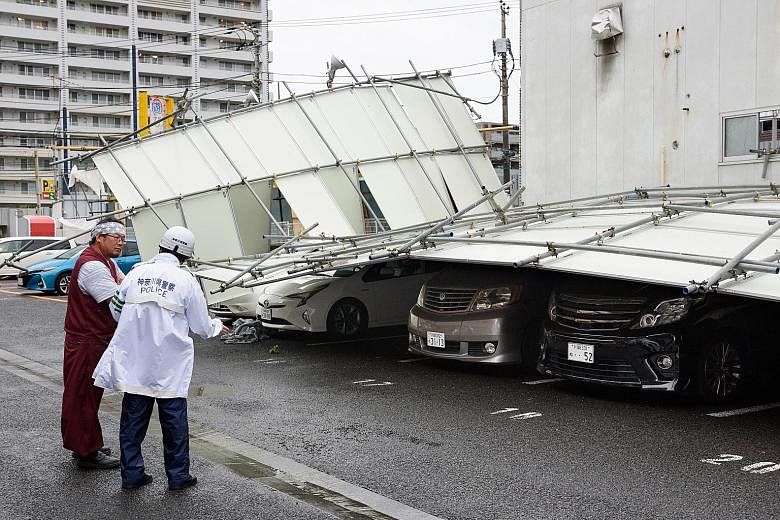 A fence blown over by strong winds in Kawasaki, Kanagawa prefecture, yesterday. Among those killed was a woman in her 50s in Tokyo, who died after she was smashed against a building by strong gusts, according to security camera footage. PHOTO: BLOOMB