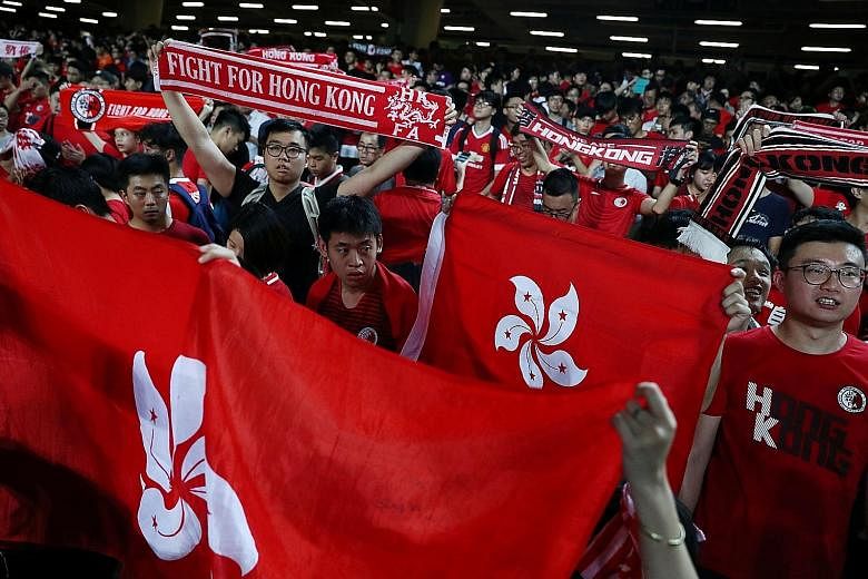 Football fans in Hong Kong Stadium yesterday showing support for anti-government protesters as Hong Kong took on Iran in a World Cup qualifier.