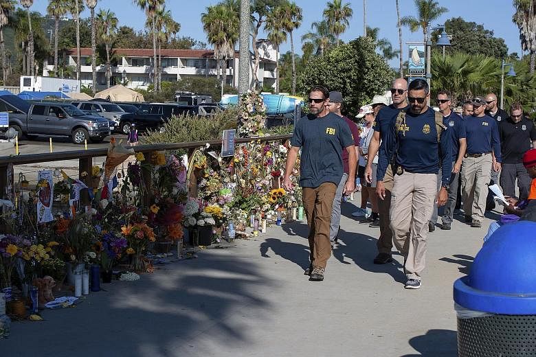 FBI agents walking past a memorial for the 34 victims of the Conception diving boat fire at the Santa Barbara Harbour. The US authorities issued a search warrant at Truth Aquatics' offices in Santa Barbara, California, on Sunday.