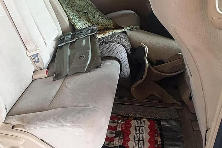 A total of 412 cartons and 640 packets of contraband cigarettes were concealed in a compartment of a car driven by a 27-year-old Malaysian on Sunday. PHOTO: ICA