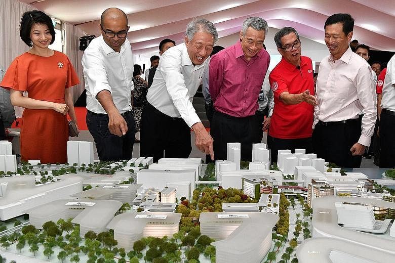 Prime Minister Lee Hsien Loong and Singapore Institute of Technology president Tan Thiam Soon (in red) looking at a model of the future SIT campus in Punggol during the ground-breaking ceremony yesterday. With them are (from left) Senior Parliamentar