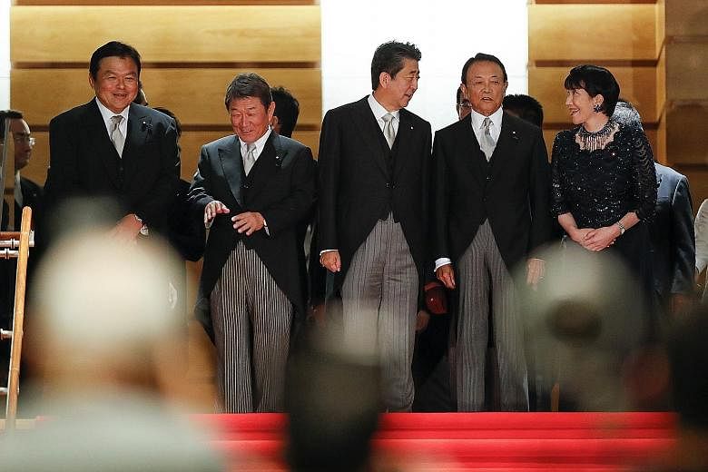Members of Japan's new Cabinet include (from left) Land, Infrastructure, Transport and Tourism Minister Kazuyoshi Akaba, Foreign Minister Toshimitsu Motegi, Prime Minister Shinzo Abe, Finance Minister Taro Aso and Internal Affairs Minister Sanae Taka