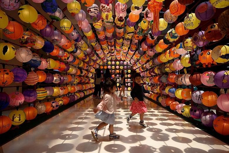 Children playing under a lantern installation at a shopping mall in Kuala Lumpur on Tuesday, ahead of tomorrow's Mid-Autumn Festival. The festival, meant to mark a bountiful harvest, is observed mainly by the Chinese. It is celebrated with eating moo