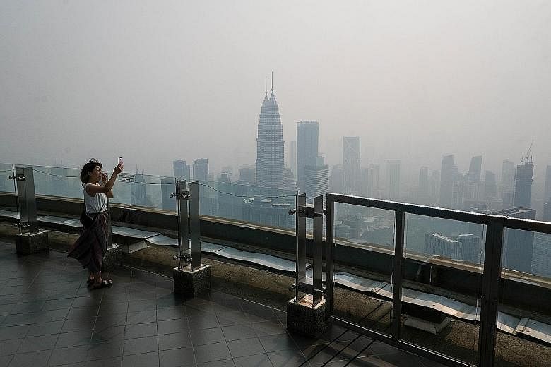 The Kuala Lumpur skyline obscured by thick haze yesterday as wind continued to blow haze coming from Kalimantan and Sumatra in Indonesia into Malaysian cities.
