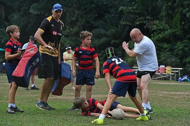 Former England international Brian Moore (in white) giving tips to youth at Singapore Cricket Club's Dempsey Field yesterday. He believes that the margins among the top eight teams now are very fine and every team need to be in peak condition to win 