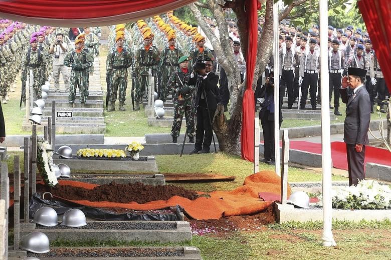 Indonesian President Joko Widodo saluting at the grave of former president B.J. Habibie at the Kalibata heroes' cemetery in Jakarta yesterday. Mr Joko called Dr Habibie "a role model for all of the nation's children". PHOTO: ASSOCIATED PRESS