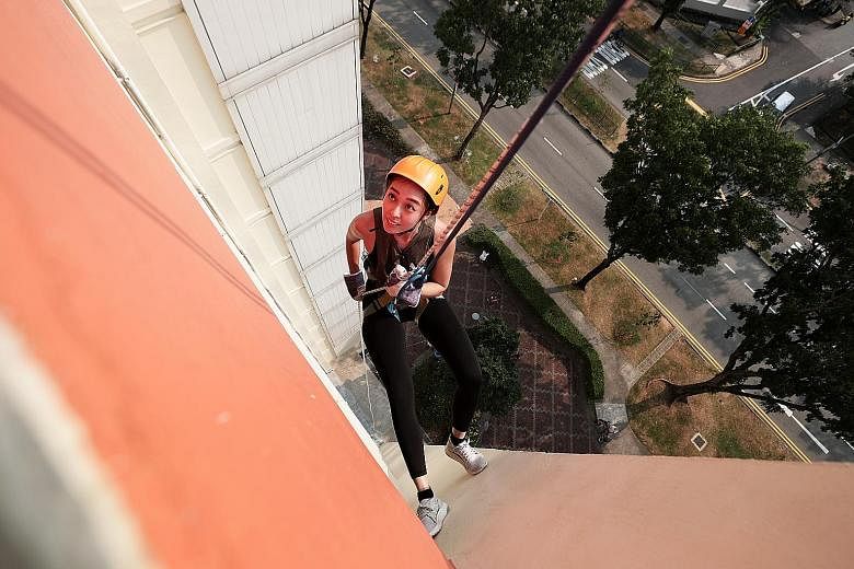 The writer practising how to walk in an L-shaped position while placing both feet against the inside of a parapet. Reporter Michelle Ng tries her hand at abseiling, an activity that should be undertaken only under the supervision of certified abseili