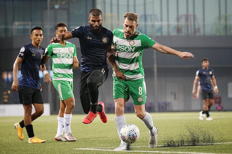 Geylang International's Barry Maguire challenging Hougang United's Anumanthan Kumar during a match between the two sides yesterday.