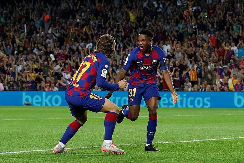 Barcelona's Ansu Fati having a Nou Camp debut to remember as he celebrates with Antoine Griezmann after scoring in only the second minute. Adding an assist later, the 16-year-old became the Spanish league's youngest player to record such a double fea