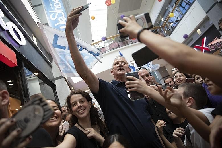 Israeli opposition leader Benny Gantz with supporters at a campaign rally in a mall in Kiryat Ono, Israel, last Friday. Mr Gantz and Prime Minister Benjamin Netanyahu are neck and neck in the election race as Israelis go to the polls tomorrow.