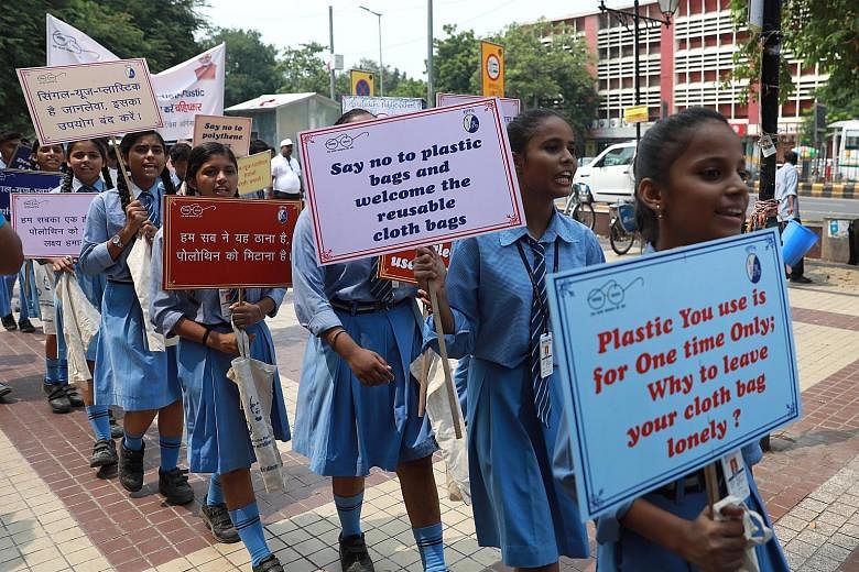 Schoolchildren in New Delhi taking part in a march last Thursday with placards and cloth bags to create awareness of the plastic pollution. PHOTO: EPA-EFE