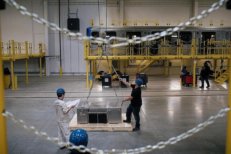 Workers moving an auxiliary power supply at CRRC Corp's Chicago plant last month. The Chinese train maker completed the US$100 million (S$137 million) facility this year in the hope of winning contracts to build subway cars and other passenger trains