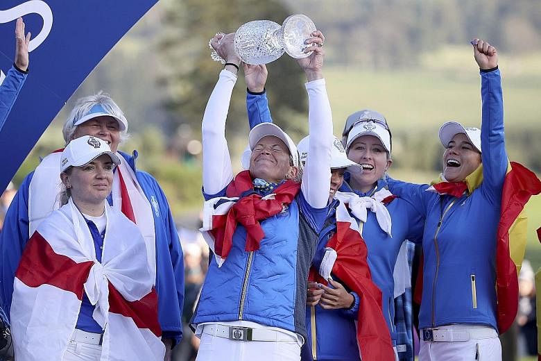 A jubilant Suzann Pettersen lifting the Solheim Cup after helping Europe beat the United States 141/2-131/2 at Gleneagles on Sunday. PHOTO: ASSOCIATED PRESS