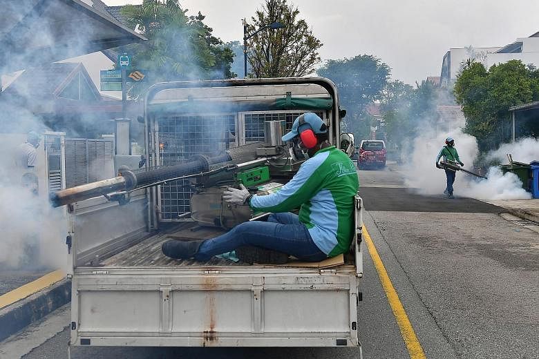 Pest control and National Environment Agency officers conducting fogging in Hemsley Avenue in Serangoon Gardens on Sunday. ST PHOTO: NG SOR LUAN