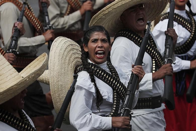 A woman in a soldier costume taking part in Mexico's Independence Day military parade in the capital's main plaza, the Zocalo, on Monday. More than 12,500 soldiers, marines and National Guards took part in the parade in Mexico City, Xinhua reported. 
